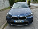 une BMW bleue garée sur le bord de la route