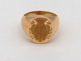 un gros plan d'une bague en or ornée d'un blason