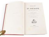 an open book with a gold bell on it