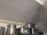 many pots and pans sitting on a shelf in a kitchen