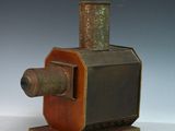 un petit objet métallique posé sur un socle en bois