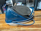 a blue and white steam iron on top of a wooden table