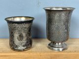 deux vases en argent posés l'un à côté de l'autre sur une table