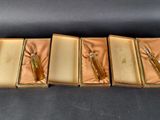 three gold boxes with scissors and a pair of scissors in them