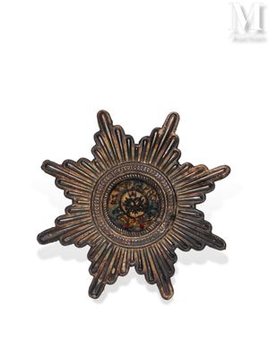 an image of a small bronze sunburst on a white background