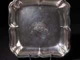 a silver plate on a black surface with a black background