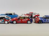 several toy cars are lined up in a row on a white surface