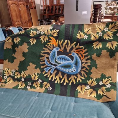 a blue couch with a green and yellow blanket on top of it