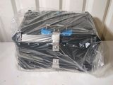 a black suitcase wrapped in plastic on a white table