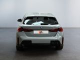 the rear end of a silver bmw car in a white room