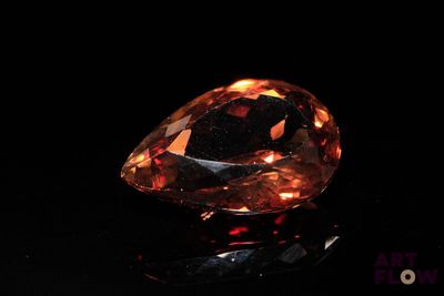 a close up of a large orange diamond on a black surface