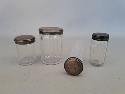 three glass jars with lids on a white surface