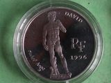 a close up of a coin in a plastic container on a green surface