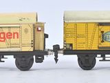 deux petits trains miniatures posés côte à côte sur une surface blanche