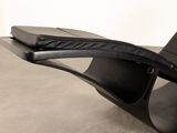 black leather chaise lounge chair with curved backrest and foot rest