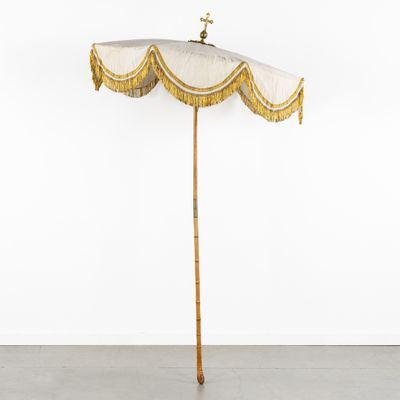 a white umbrella with a gold fringe hanging from the top of it
