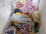 a pile of clothes in a white bag on the floor