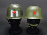 two green helmets with red stars on them sitting on top of a black mannequin head