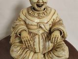 une petite statue représentant un homme assis sur une table
