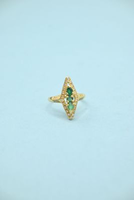 a close up of a gold ring with a green stone