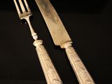silverware on a black table with a knife and fork
