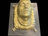 une image représentant une sculpture en or représentant la tête d'un homme