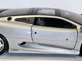 a silver model of a sports car on a white surface