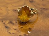 an image of a yellow ring sitting on top of a wooden table