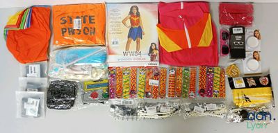 supplies laid out on a white surface including a red shirt, orange shirt, and other items