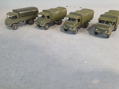 several toy army trucks are lined up in a row on a table