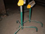 two green and yellow pipe holders sitting on the ground