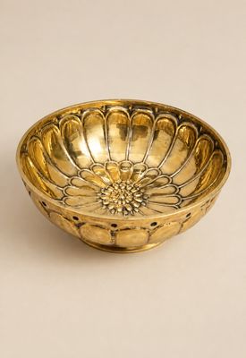 assiette dorée ornée d'un motif floral sur fond blanc
