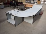 un bureau blanc avec une chaise noire au milieu