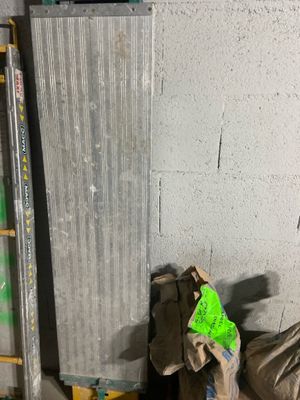 a pile of bags of garbage next to a metal radiator