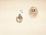 two pieces of jewelry on a table with a price tag