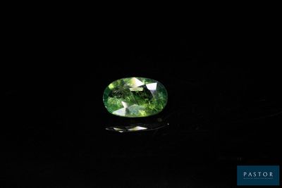 une tourmaline verte posée sur un fond noir