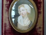 portrait d'une femme en robe blanche dans un cadre en velours rouge