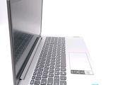 a silver laptop with a black keyboard on a white surface