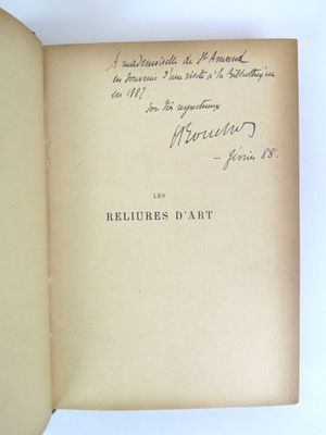 un livre ouvert avec une écriture dessus, posé sur une table