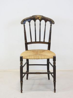 an image of a wooden chair with a wicker seat on a white floor