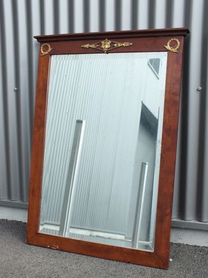 un grand miroir posé par terre à côté d'un bâtiment