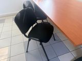 deux chaises noires et une table en bois dans une pièce