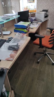 a desk with a computer and a chair in a room
