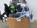 a cardboard box full of assorted items on the ground