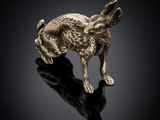 a gold rabbit figurine on a black surface