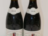 deux bouteilles de vin posées sur une table l'une à côté de l'autre