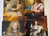 quatre livres posés sur une table, à côté d'un tableau représentant un homme et une femme