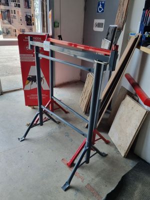 une photo d'un établi dans un garage, avec des outils posés par terre