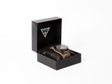 la montre se trouve dans un coffret noir posé sur une surface blanche