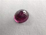 a close up view of a pink sapphire stone on a white surface